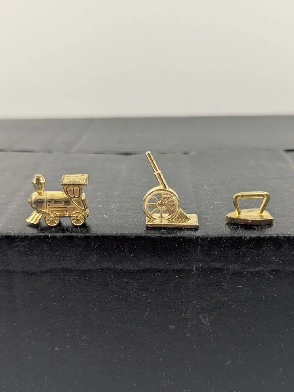 Three gold color monopoly replacement pieces train, canon, iron